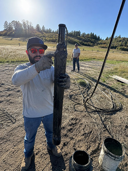 DAK Drilling technician removing damaged well pump equipment from a rural Colorado water well during maintenance and repair service